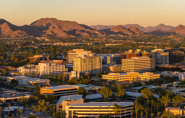 A cityscape with buildings and mountains in the background.