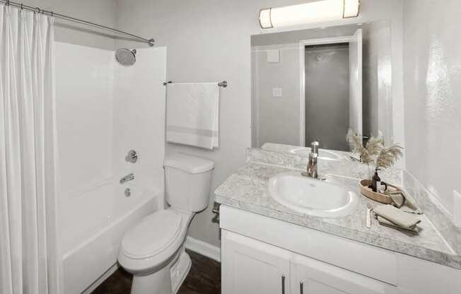 a white bathroom with a sink toilet and shower