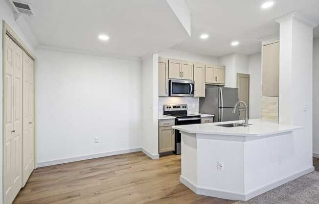 a white kitchen with a large island and a stainless steel