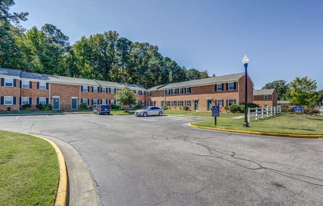 a street in front of a brick building with a parking lot