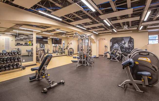 A gym with a variety of equipment including weights and machines.