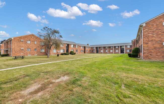 the courtyard of a large brick building with a grassy field