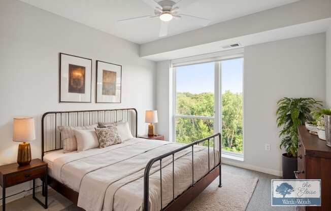 a bedroom with a bed and a large window