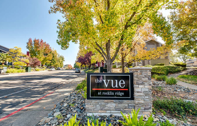 A sign for The Vue at Rocklin Ridge is in front of a tree.