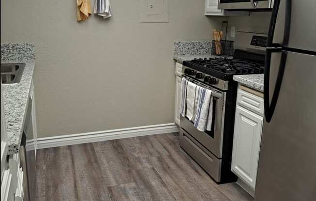 A kitchen with a black stove top oven and a black refrigerator.