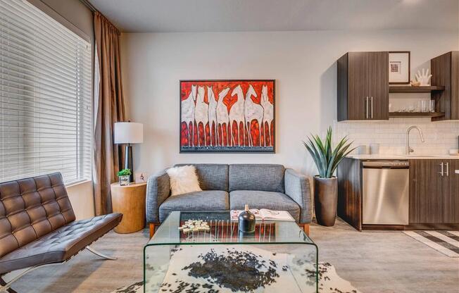 a living room with a couch and a glass table  at Affinity 56 Apartments in West Jordan, Utah