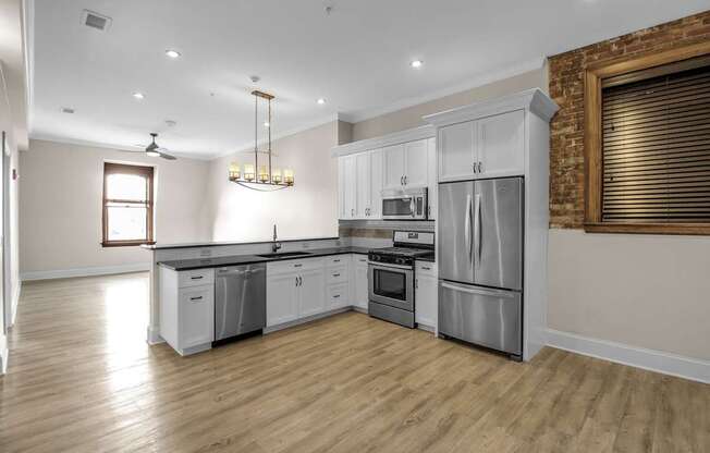 A modern kitchen with wooden floors and stainless steel appliances at The Knights @ 506 Delaware Apartments, Buffalo, New York