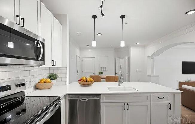 A modern kitchen with a stainless steel oven and a white countertop.