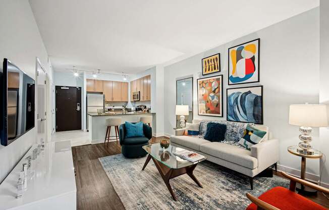 A living room with a couch, chair, and pictures on the wall.