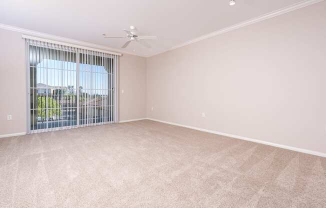 a bedroom with a large window and a ceiling fan