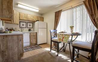 a kitchen and dining area with a table and chairs and a refrigerator