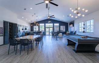 a spacious game room with a pool table and dining area