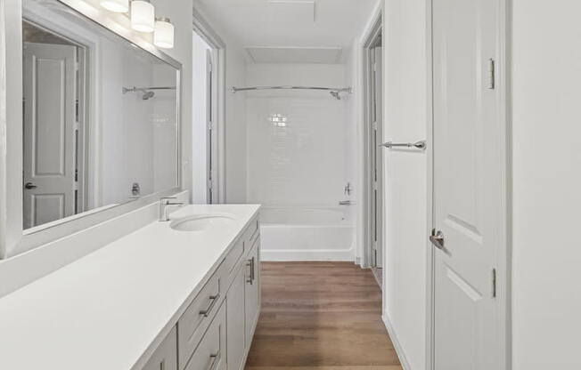 A white bathroom with a sink and mirror.