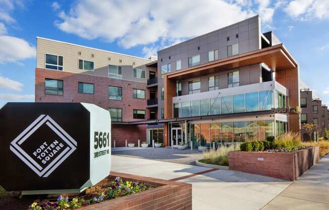 a building with a large sign in front of it with the entrance to a campus