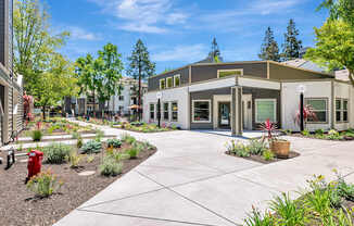 A building with a grey roof and a red fire hydrant in front of it.