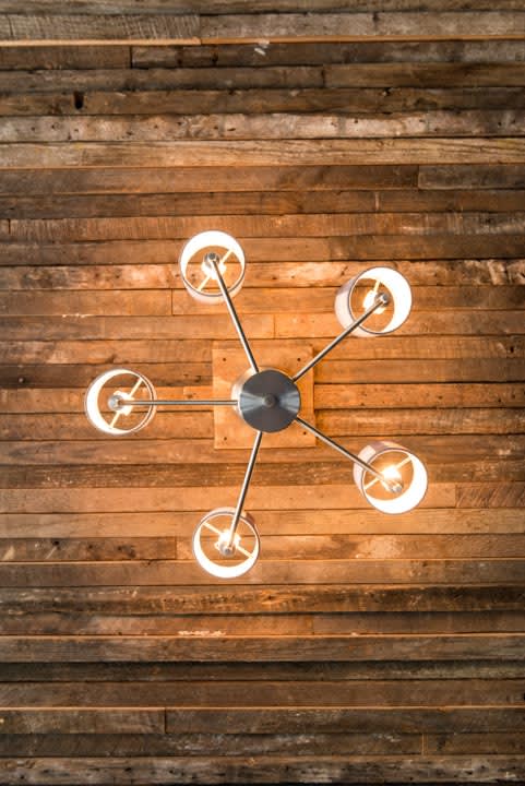 a clock hanging on a wooden wall