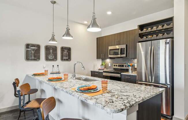 A kitchen with a marble countertop and a refrigerator.