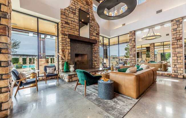 A living room with a stone fireplace and a large window.