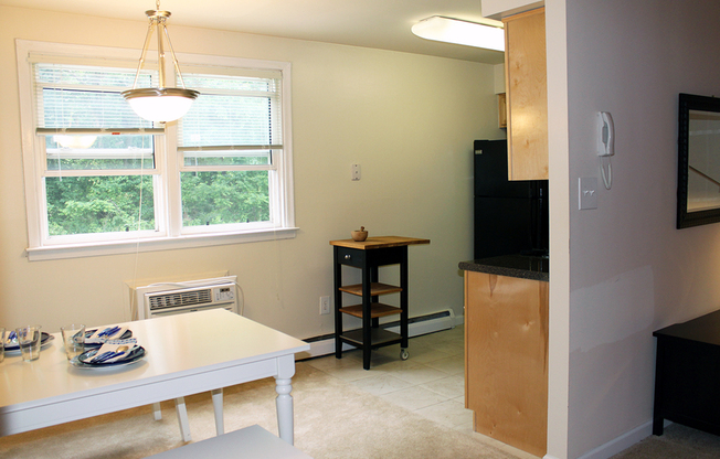 Spacious model kitchen with wood cabinets and access to dining space in Hatboro, PA apartments