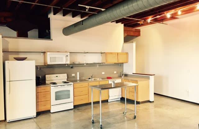 an empty kitchen with white appliances and a table