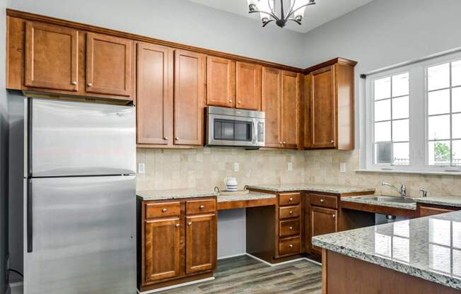 A kitchen with wooden cabinets and a granite countertop.