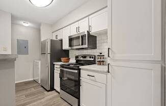 a renovated kitchen with white cabinets and stainless steel appliances