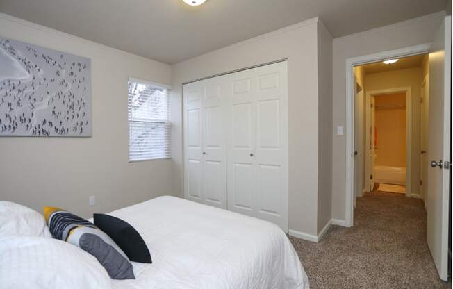 Bedroom with full side bed and 2 panel closet doors.at Woodhaven, Washington