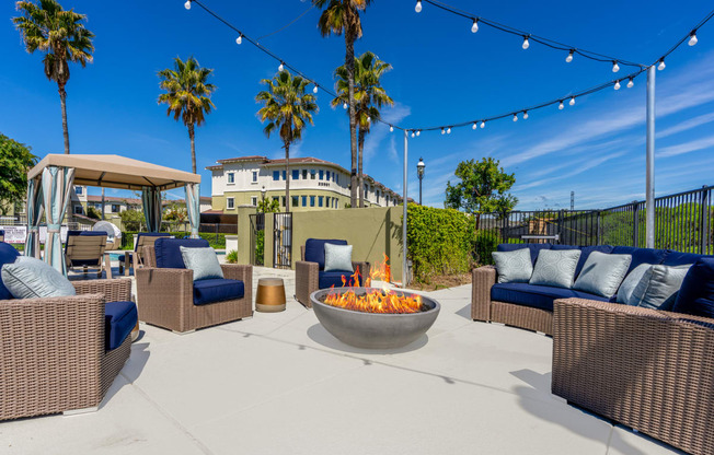 the outdoor patio has a fire pit and seating around it