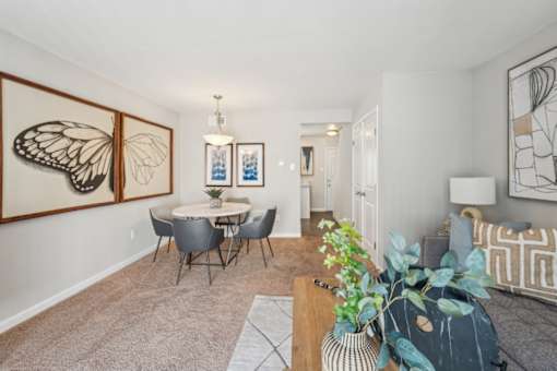 A living room with a dining table and chairs at Staples Mill Townhomes Apartments, Richmond