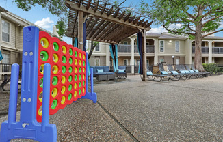 A large blue and red foosball table in the middle of a courtyard.