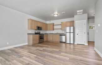 a kitchen with wooden cabinets and a stainless steel refrigerator