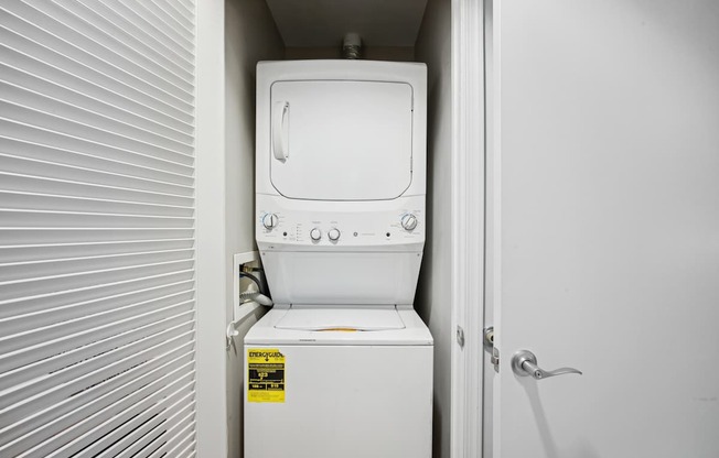 A white toilet with a sticker on it is in a small room.