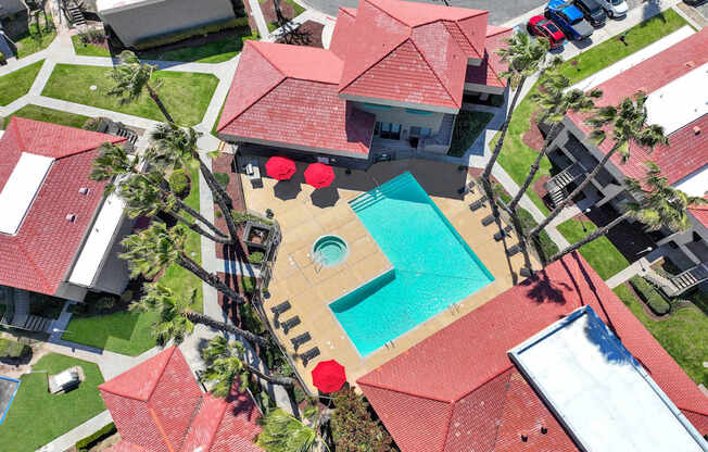 A red roofed house with a swimming pool in the backyard.