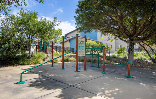 a playground in a park with trees and a building