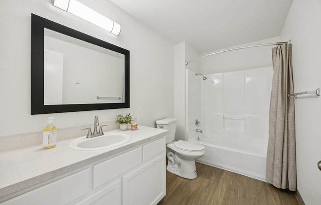 A white bathroom with a sink, toilet, and bathtub.