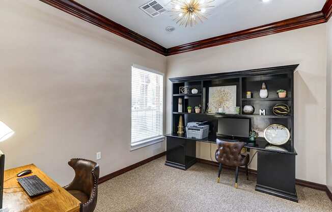 A room with a desk, chair, and a bookshelf.