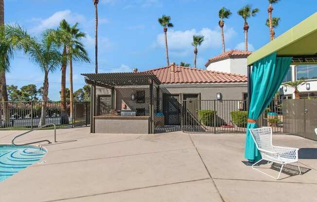 a backyard with a pool and a gazebo with palm trees in the background