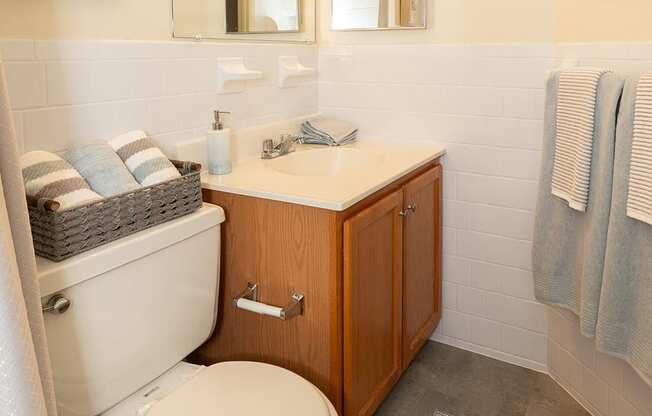 A bathroom with a toilet, sink, and mirror.