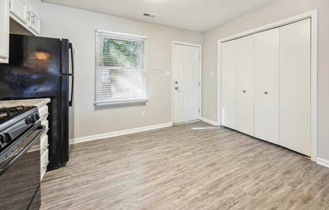 an empty kitchen and living room with a stove and refrigerator