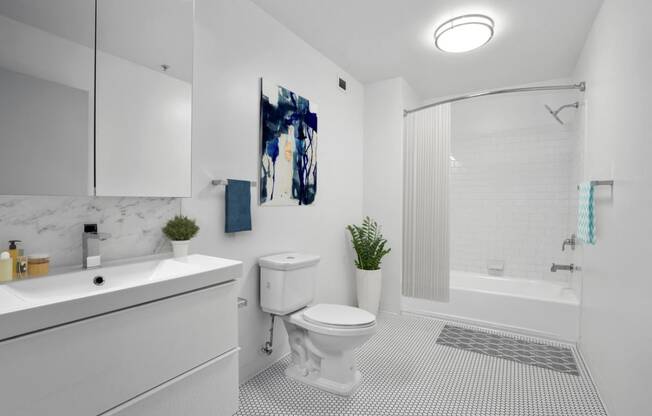 a bathroom with a white sink and toilet next to a white bathtub