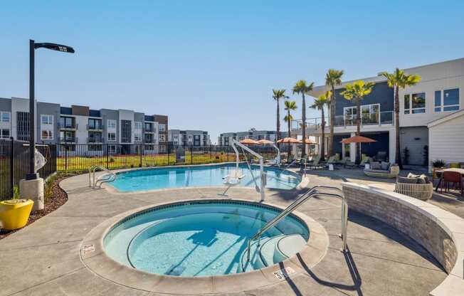 a hot tub and pool with a building in the background