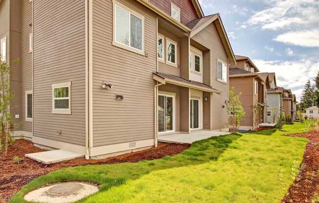 A row of houses with brown siding and white trim.