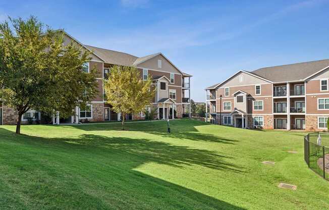 A large grassy area in front of apartment buildings.