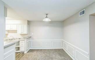 A kitchen with white cabinets and a countertop.