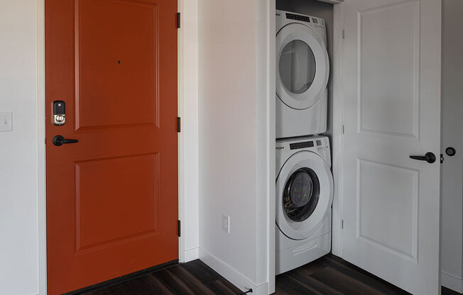 a door is open to a laundry room with a washer and dryer at The Landing at 1001 NP, Fargo, North Dakota 58102