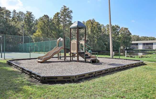 A playground with a slide and a wooden swing set.