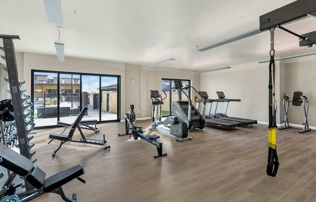A gym with a variety of equipment including treadmills, weights, and exercise machines.
