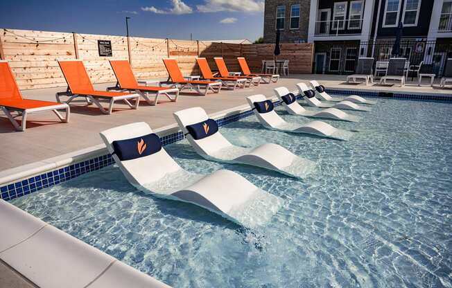 a reflection of lounge chairs in a pool of water