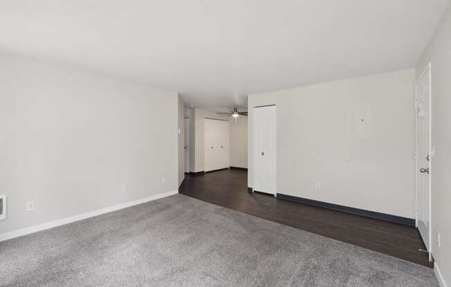 an empty living room with white walls and wood flooring