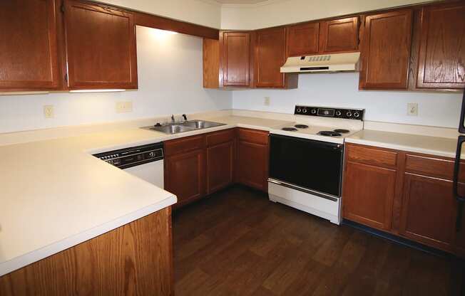 A kitchen with wooden cabinets and a white counter top.